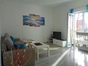 ein Wohnzimmer mit einem Sofa, einem Tisch und einem TV in der Unterkunft Apartment Prunus in Dubrovnik