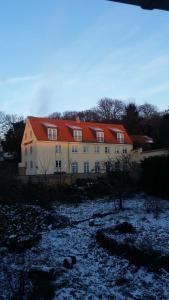 a large house with an orange roof in a field at Hotel Ole Lunds Gaard in Kalundborg
