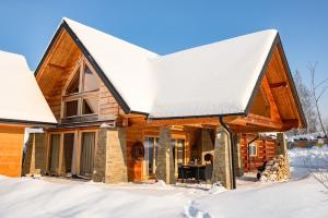 a log home in the snow at Łabowska Chata - Basen, Sauna, Grota solna in Łabowa