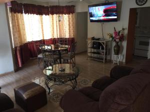 sala de estar con sofá, mesa y TV en Chill on the Hill en Ocho Rios