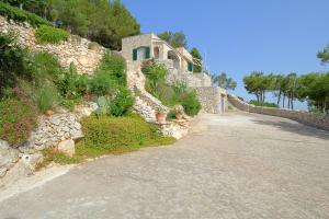 une maison en pierre sur une colline avec une allée. dans l'établissement Ville Belvedere Luxury Accommodation, à Gagliano del Capo