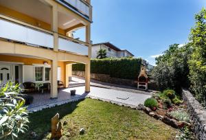 a view of a house with a yard at Sara Apartments Malinska in Malinska