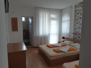 a hotel room with two beds and a window at Къща за гости "Матеви" in Obzor