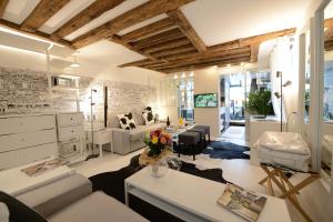 een grote woonkamer met witte meubels en een woonkamer bij Les Patios du Marais 2 in Parijs