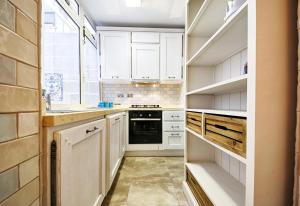 a kitchen with white cabinets and a black oven at Valletta Heritage Town House in Valletta