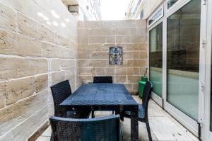 a table and chairs in a room with a window at Valletta Heritage Town House in Valletta