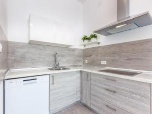 Una cocina con gabinetes blancos y un fregadero. en Apartment in Croatia with Sea Views, en Dramalj