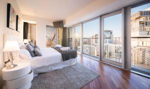 a bedroom with a bed and large windows at You Stylish Beach Apartments in Barcelona