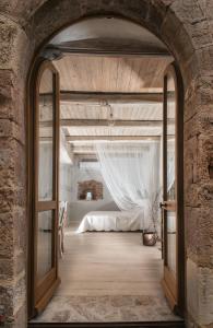 CrocemaroggiaにあるIl Castello Di Perchiaのベッドルーム(ベッド付)へ続くアーチ道