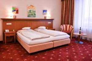Habitación de hotel con cama y silla en Hotel Alexandra, en Wels