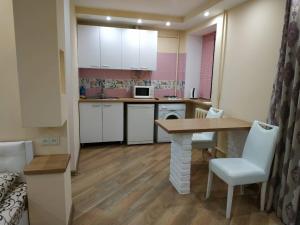 - une petite cuisine avec une table et des chaises dans la chambre dans l'établissement Apartments in the Center Maidan, à Rivne