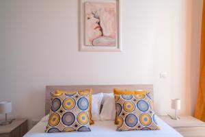 una camera da letto con un letto con due cuscini e un quadro di Accasarte P01 a Napoli