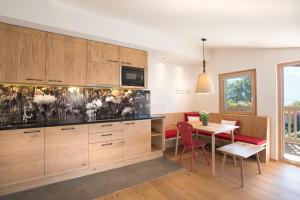 a kitchen with wooden cabinets and a table with chairs at Hapimag Ferienwohnungen Zell am See in Zell am See