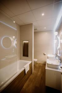 a bathroom with a tub, toilet and sink at The Hotel Unforgettable - Hotel Tiliana by Homoky Hotels & Spa in Budapest
