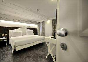 A bed or beds in a room at Al Theatro Palace