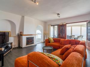 a living room with an orange couch and a tv at Belvilla by OYO Casa Eldorado in Benissa