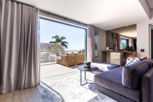 een woonkamer met een bank en een groot raam bij The Junction Boutique Hotel in Plettenbergbaai