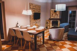uma sala de jantar com mesa e cadeiras e uma sala de estar em Leśna Oaza em Borek