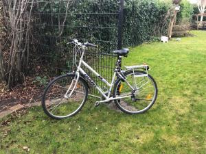 ein Fahrrad im Gras neben einem Zaun geparkt in der Unterkunft Guest House Open Doors in Almere