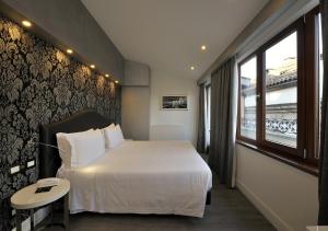 A bed or beds in a room at Al Theatro Palace