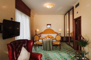 a hotel room with a bed and a table at Grand Hotel Excelsior in Chianciano Terme