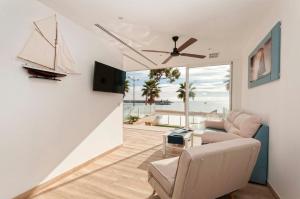 Una sala de estar con un sofá y un ventilador de techo. en Suites at Sea, en Villajoyosa