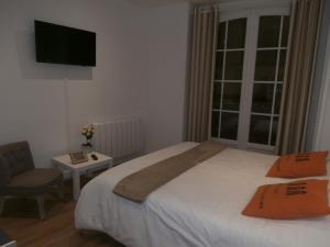 a bedroom with a bed and a television at au Claire de lune in Dieppe
