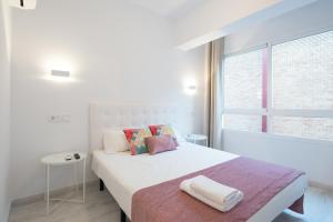 a white bedroom with a large white bed and a window at Nuevo centro 3 hab 2 baños ac wifi in Málaga