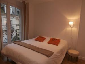 a white bed sitting in a bedroom next to a window at au Claire de lune in Dieppe