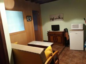 sala de estar con sofá y microondas en Apartamentos La Ceña, en Novales