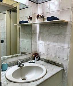 W łazience znajduje się umywalka i lustro. w obiekcie Residenza in Palazzo d'Epoca w Mediolanie
