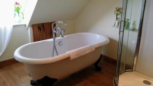 a bath tub with a faucet in a bathroom at Althea House with parking in Padstow