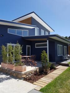 a blue house with a table in front of it at Zeally Bay Stay Deep Ocean in Torquay