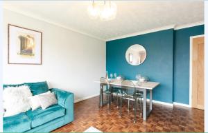 a blue living room with a blue couch and a table at Gayton Court 2-Bedroom Flat in the Centre of Reigate in Reigate