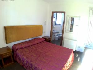 a bedroom with a bed with a red bedspread at Podere 269 in Castiglione della Pescaia