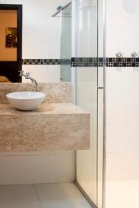 a bathroom with a sink and a glass shower at Bras Palace Hotel in Sao Paulo