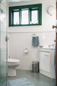 a bathroom with a toilet and a sink and a window at Peppercorns B&B in McLaren Vale