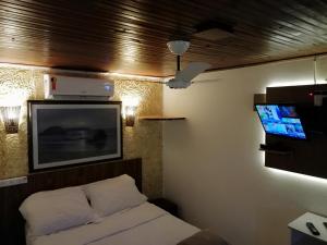 una camera da letto con un letto e una TV a schermo piatto di Hotel Talu ad Angatuba Altre 29 foto