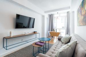 マラガにあるCentrico apartamento 2 dormのリビングルーム(ソファ、壁掛けテレビ付)