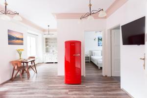 einen roten Kühlschrank im Wohnzimmer mit einem Tisch in der Unterkunft Barbo Palace Apartments and Rooms in Ljubljana
