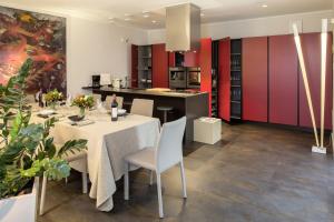 アッシジにあるVilla Vitaのキッチン、ダイニングルーム(赤いキャビネット、テーブル、椅子付)