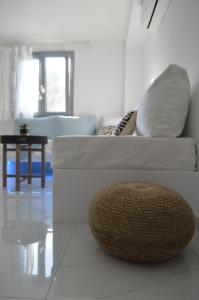 a white living room with a couch and a table at Small Paradise in Andros