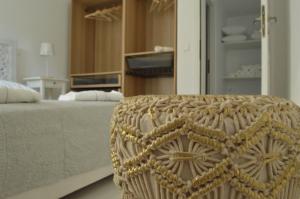 a bedroom with a bed and a wicker chair at Small Paradise in Andros