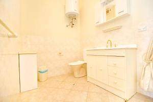 a white bathroom with a sink and a toilet at Apartments Villa Steffi in Prizba +40 photos
