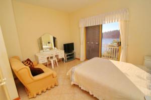 a bedroom with a bed and a chair and a mirror at Apartments Villa Steffi in Prizba