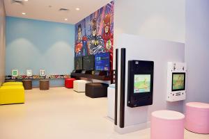 a room with a video game arcade machine and stools at Yas Island Rotana Abu Dhabi in Abu Dhabi
