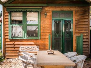 a table and chairs in front of a wooden house at Peppercorns B&B in McLaren Vale