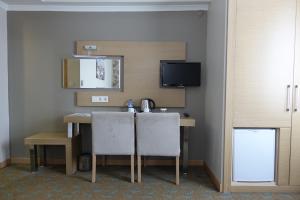 a room with a table with two chairs and a television at Otel Mutevelli in Kastamonu