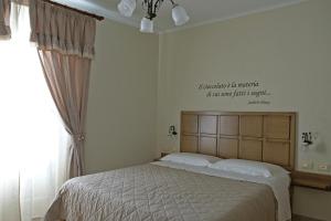 Un dormitorio con una cama con un cartel en la pared. en ChocoHouse, en Ragusa