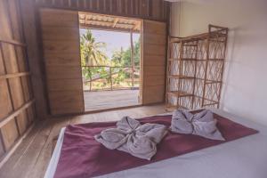 a bed in a room with a window and a bedspread at Bonsai in Koh Rong Sanloem